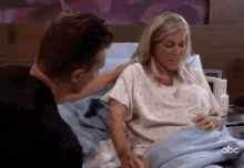 a man and a woman are sitting in a hospital bed .