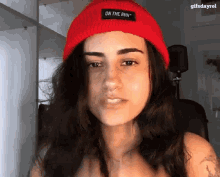 a woman wearing a red hat that says on the run on it