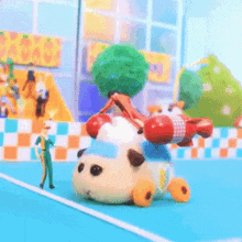 a cartoon character is riding on the back of a toy car with a tree on top of it .