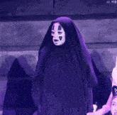 a woman in a purple costume with a mask on her face is standing on a stage .