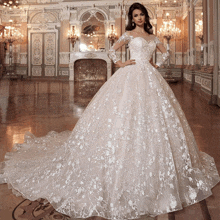 a woman in a white ball gown is standing in a room
