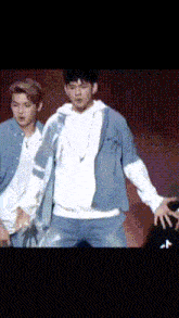 a man in a blue jacket is dancing on stage