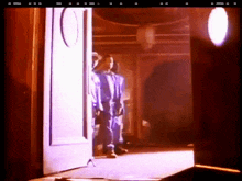 a man in a blue suit stands in front of a door