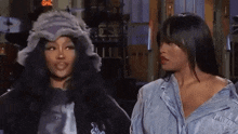 two women are standing next to each other in a room .