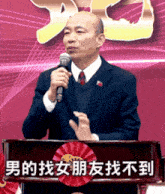 a man stands at a podium with chinese writing