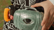 a person is holding a toy that looks like a camera with an eye in it