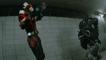 a man in a red and white costume is holding a gun in front of a brick wall