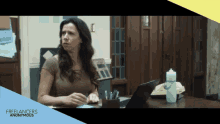 a woman sits at a desk with a laptop and a water bottle with the words freelancers anonymous on the bottom