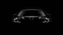 the front of a black car with the headlights on