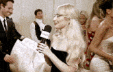 a woman in a black dress is holding a microphone that says usa