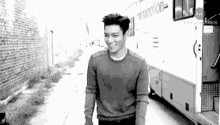 a black and white photo of a man walking down a sidewalk .
