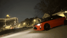 a red car is parked in front of a hotel