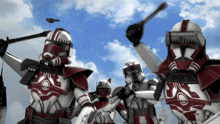 a group of clone troopers are holding weapons in the air