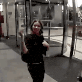 a woman is walking down a hallway with a bag on her shoulder .