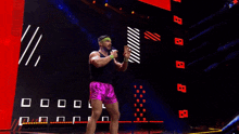 a wrestler is standing in front of a large screen with the words `` my bad '' .