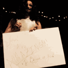 a person holding up a sign that says you are amazing
