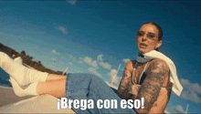 a woman with a tattoo on her arm is laying down with the words brega con eso written below her