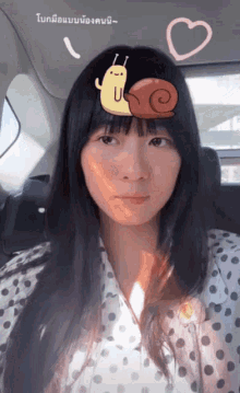 a woman in a polka dot shirt has a snail on her forehead