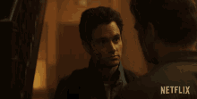 two men are looking at each other with a netflix logo in the background