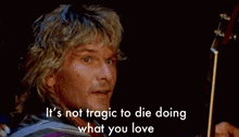 a man playing a guitar with the words " if you tragic to die doing what you love " above him