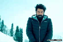 a man with a beard is wearing a jacket that says pranay_varma on it