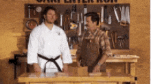 a man in a karate uniform is standing next to a man in an apron