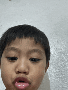 a young boy making a face with his tongue sticking out