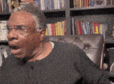 a man is sitting in front of a bookshelf with a book called animal year on it
