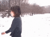 a woman in a striped shirt walking in the snow