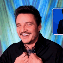 a man with a mustache is smiling in front of a blue curtain