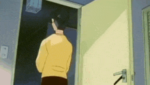 a man in a yellow shirt is standing in a doorway .
