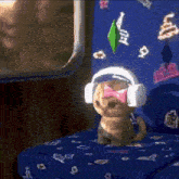 a stuffed animal wearing headphones and a pink bow is sitting on a bed