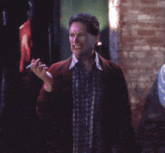a man in a red jacket is smoking a cigarette