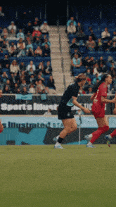 a soccer game is being played in front of a sports illustrated sign