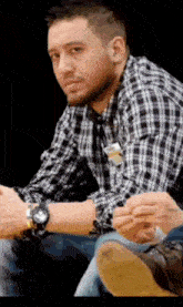 a man wearing a plaid shirt and a watch