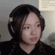 a close up of a woman wearing headphones making a funny face .