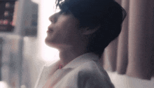 a close up of a man 's face with a white shirt on