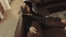 a person laying on a couch with the letter d on the bottom right corner