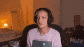 a woman wearing headphones is sitting in a chair looking at the camera .