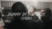 a man in a hoodie is smoking a cigarette in a kitchen with the words bunny in the box written on the bottom