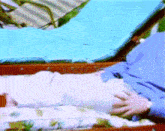 a man in a blue shirt is laying in a chair with his hands on his stomach