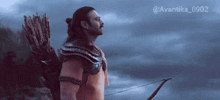 a man holding a bow and arrow with the hashtag avantika_0902 on the bottom right
