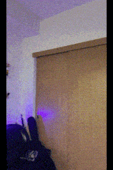 a bedroom with a purple light behind a closet