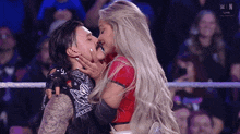 a man and a woman kissing in a wrestling ring .