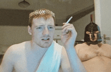 a shirtless man wearing a laurel wreath smoking a cigarette