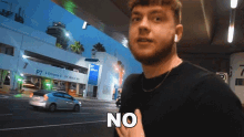 a man standing in front of a parking garage with the word no on his chest