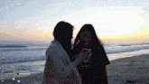 two women standing on a beach with a sunset in the background and today 's subs are 357