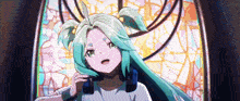 a girl with green hair is sitting in front of a stained glass window .