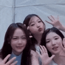 a group of three girls are posing for a picture together .