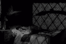 a black and white photo of a person sleeping in bed